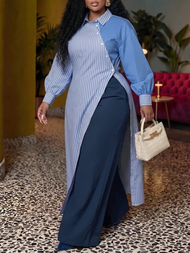 Plus-size woman in a striped asymmetric blue shirt and navy wide-leg trousers.
