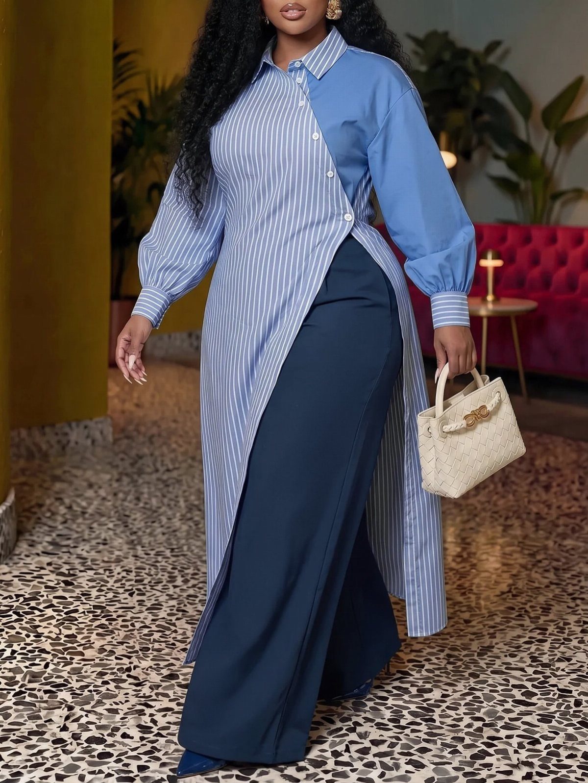 Plus-size woman in a striped asymmetric blue shirt and navy wide-leg trousers.