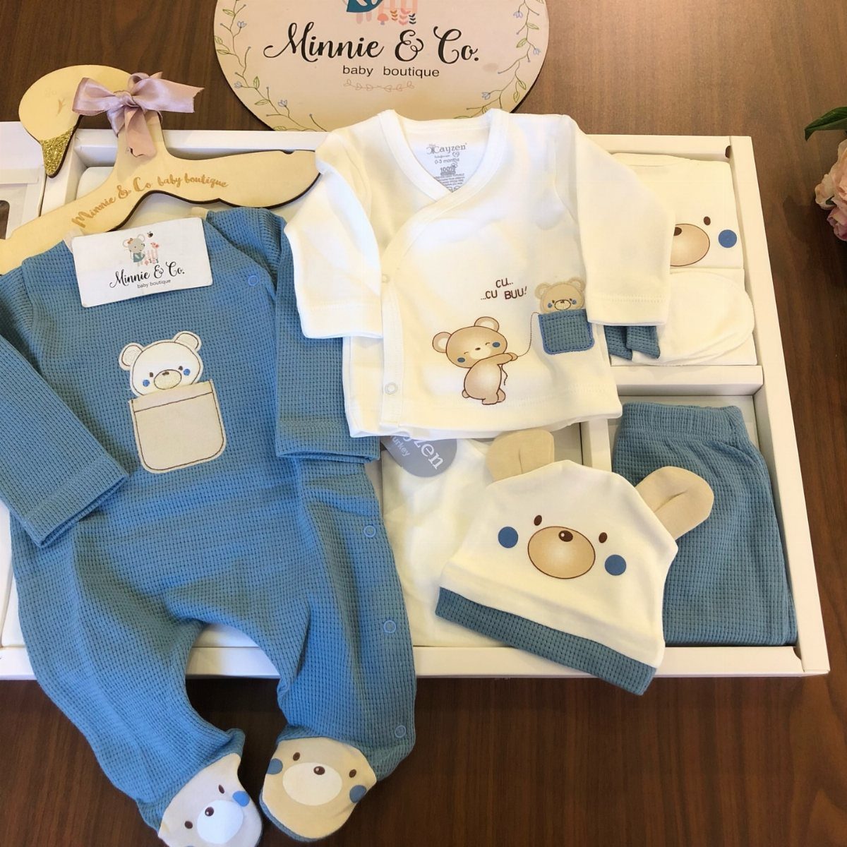 Baby clothing gift set with blue romper, white shirt, and bear hat in box