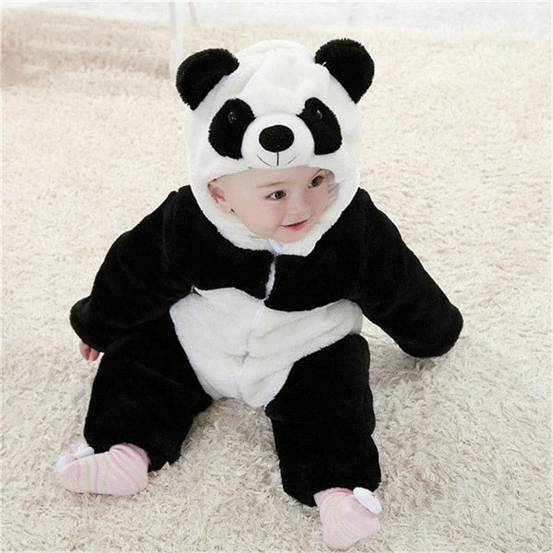 Baby wearing a plush black and white panda costume sitting on white carpet.