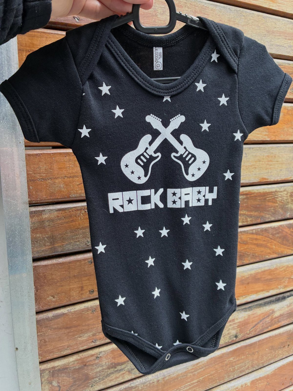 Black infant bodysuit with white stars, crossed guitars, and ROCK BABY text.